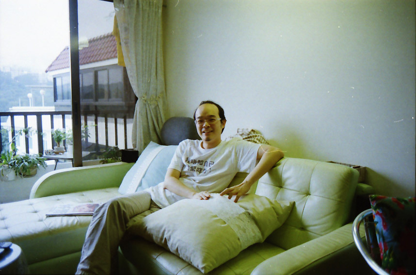 Pak relaxes on the sofa of his and his wife’s green motif living room. From the southern facing balcony, Tseung Kwan O Village across the way remains hidden from view behind the hill in the distance, except for a single telephone tower, not pictured here. Pak refers to the recent addition to the landscape as the local Eiffel Tower, and commemorates it with a miniature statue in one of the flower pots.