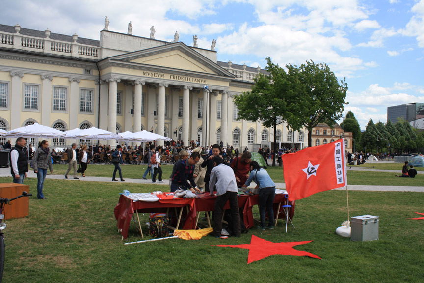 For his guerrilla art project, “Red Stars Lighten Europe,” CAI QING set up a table on Friedrichsplatz in front of the Fridericianum museum on the opening days.