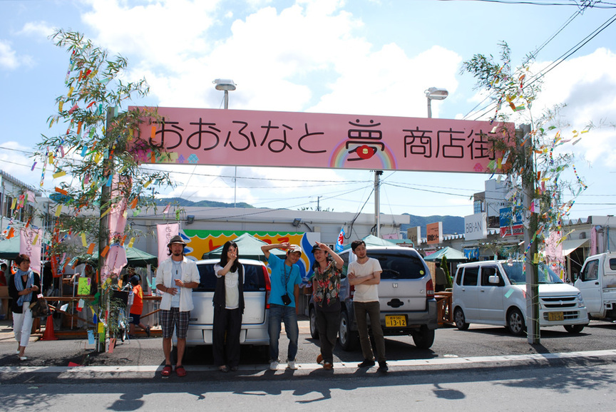 Some of the Yappeshi Matsuri organizers and volunteers pose beneath the Yume Shotengai street sign.