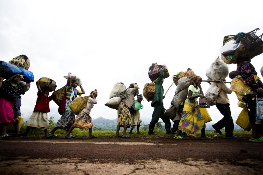 DEMOCRATIC REPUBLIC OF THE CONGO. North Kivu, Kibumba. 2008. Over 25, 000 people carry their belongings as they flee one of the main refugee camps due to fighting on Monday, Oct. 27, 2008 near Kibumba in eastern Congo. Government soldiers were forced to retreat as they were being pushed closer to Goma by rebels of renegade Gen. Laurent Nkunda. Copyright the artist.