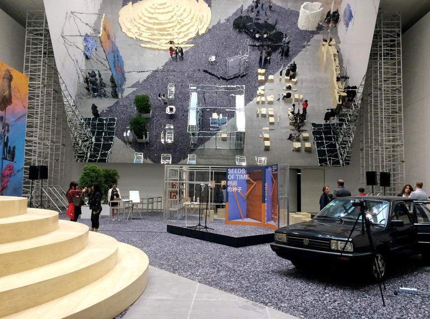 Installation view of the exhibition “Seeds of Time” at the Shanghai Himalayas Museum, including LIAM GILLICK’s Construcción de Uno (A Prequel) (2006) (forefront, right), in which visitors were invited to sit inside the stationary Volkswagon Golf Mk1 and read a fictional story about a group of laborers in a post-industrial European setting, whose very identity relies on the re-operation of a car factory long dormant.