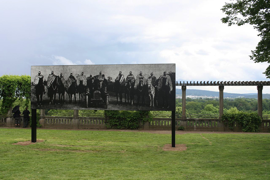 Near Grimmwelt, on the Weinberg-Terrassen, is NATHAN POHIO’s billboard, Raise the anchor, unfurl the sails, set course to the centre of an ever setting sun! (2015), which appropriates two photographs from 1905 to depict a British governor general and his wife, Lord and Lady Plunket, arriving in Tuahiwi, Aotearoa, where they are welcomed by Ngāi Tahu elders on horseback. This is one of several works by indigenous artists in Documenta 14 that address the history of land-rights under European colonialism.