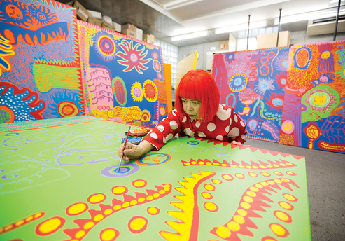 YAYOI KUSAMA in her Tokyo studio in April, 2013, working on a painting from the series “My Eternal Soul.” Photo by Yuriko Nakao for ArtAsiaPacific.