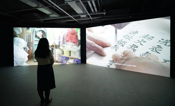 Installation view of JUNG YEONDOO’s A Girl in Tall Shoes, 2018, HD video with color and sound: 50 minutes 46 seconds, with a set of four embroidery and oil paintings on canvas, 100 × 80 cm each, at the Annex, Hong Kong, 2018.