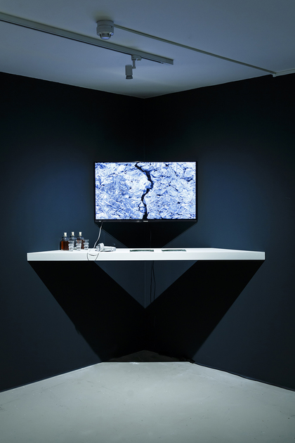 Installation view of TUAN MAMI’s In a Breath – Nothing Stands Still, 2018, bottles of homemade wine with glasses, wine-making instruction booklet and a video with color: 30 min., at “UnAuthorised Medium,” Framer Framed, Amsterdam, 2018. Photo by Eva Broekema. Courtesy Framer Framed.