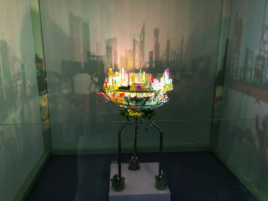 Contemporary by Angela Li (Hong Kong) presented ANGELA YUEN’s City Rhapsody – Project Roseate (2018), an installation made from locally sourced manufactured objects, such as plastic toys and stationary. The sculpture rotates around a light source and projects the Hong Kong skyline onto the surrounding white walls.