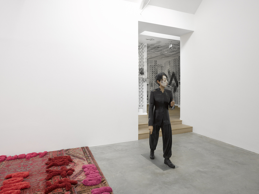 Installation view of (left) LIN TIANMIAO’s Producing Patterns, 2014, carpets in variable sizes, 9.4 × 13.43 m; and (right) XIANG JING’s Whole Dark, 2005, paint on fiberglass, 170 × 46 × 71 cm, at “Afterimage: Dangdai Yishu,” Lisson Gallery, 2019. Copyright the artists.