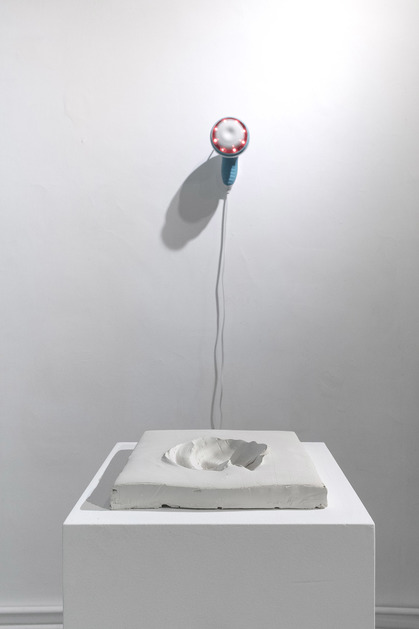 Installation view of CHRIS SHEN’s Rocago MM-310, 2019, modified massage machine and clay, 18 × 19 × 3.5 cm, at “Cold Hands, Warm Heart,” Bedroom, Hong Kong, 2019.