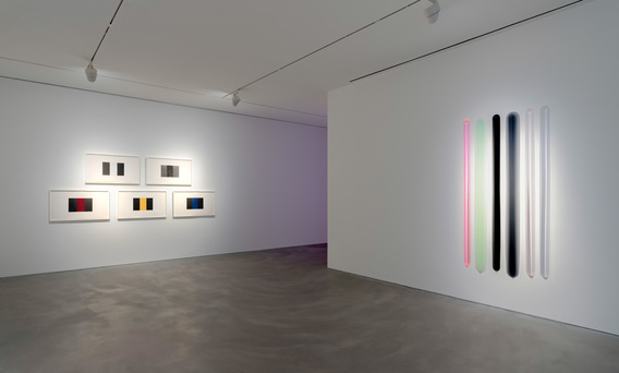 Installation view of (left) MARY CORSE Untitled (Band), 2019, set of five relief prints with glass microspheres, 50.8 × 88.9 cm each; and (right) PETER ALEXANDER’s Butter Your Grits (Don’t That Just?), 2020, urethane, 195.6 × 99 cm, at “Bloom of Joy,” Pace Gallery, Hong Kong, 2020.